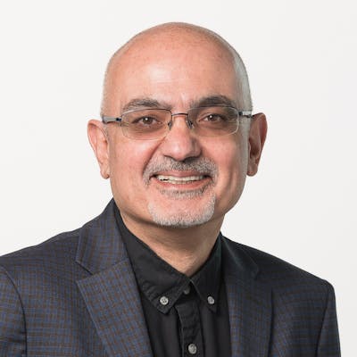 Portrait of Armen Megerdoomian in business casual attire on a white background.