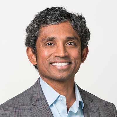 Portrait of Susendar Muthukumar in a business casual suit on a white background.