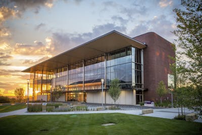The sun is behind the large windows at the KCUMB center at sunset.