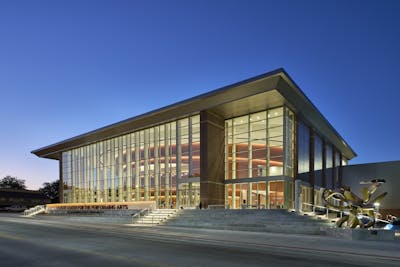 Outside the McKnight Center for the Performing Arts at night you can view the enormous glass wall facade of the entrance.