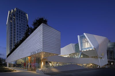 Exterior view of the Orange County Museum of Art lit up at night.