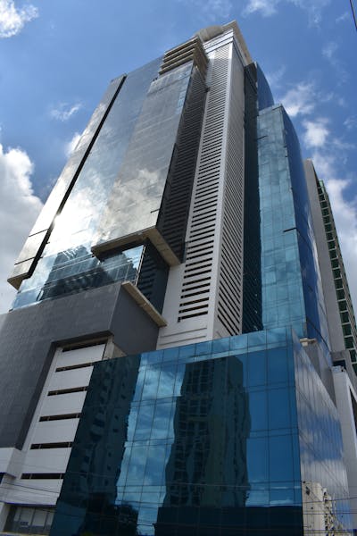 Side view of the Panama Business Tower, where you can see the reflection of the clouds in the windows.