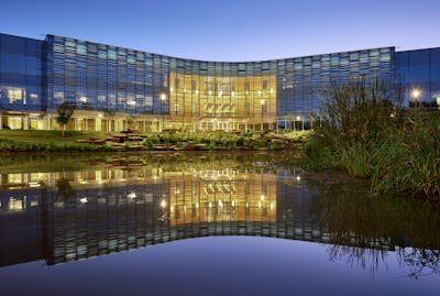 At night, the lights of Wildwood Corporate Centre are reflected in the water feature next to the building.